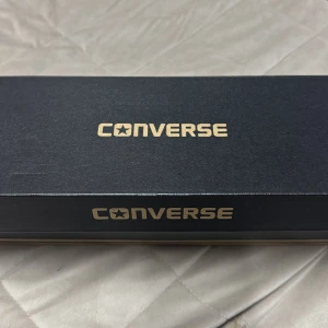 Vita sneakers från Converse - Säljer ett par helt nya klassiska vita Converse sneakers med snörning. Strl 38.5 Skorna har en vit gummisula och är tillverkade i canvasmaterial. Perfekta för en stilren och avslappnad look.