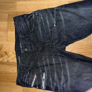 Svarta jeans med slitningar - Snygga svarta jeans med coola slitningar och en klassisk femficksdesign. 