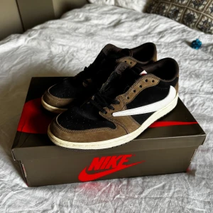 Air Jordan 1 low og Travis Scott  - Säljer ett par Nike Air Jordan low og Travis Scott. OBS ej äkta. Endast använda några gånger. Säljes pga av jag inte använder dom längre. Dom är i bra skick och jag skickar med lite extra skosnören också! 