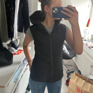 Svart dunväst från Zara - Snygg svart dunväst från Zara med dragkedja framtill. Perfekt för lager-på-lager under kyligare dagar. Västen har en stilren design och är lätt att matcha med olika outfits. Använts fåtal gånger