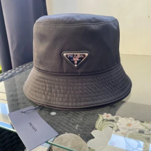 Svart bucket hat från Prada - En svart Prada hat priset kan diskuteras vid snabb affär.