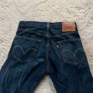 Levi's 501 jeans - Säljer ett par klassiska Levi's 501 jeans i mörkblå denim. De har en rak passform och är tillverkade i slitstarkt jeansmaterial. Dem är i bra skick och har faktiskt aldrig använt de då dem bara legat i garderoben sen de köptes. 