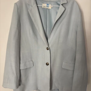 Ljusblå kavaj från NLY Trend - Snygg ljusblå kavaj från NLY Trend med klassisk design och två knappar framtill. Kavajen har långa ärmar och två fickor. Perfekt för en stilren look.