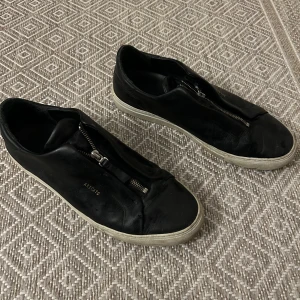 Svarta skor från Axel Arigato - Svart skor med dragkedja från Axel Arigati. Skriv om du undrar något. Mvh Plick