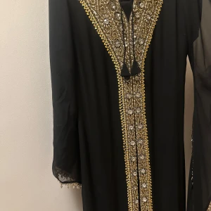 Elegant klänning / abaya - En jätte fin elegant klänning. Köptes från Dubai. Mycket fin kvalité och passas till bröllop, event osv. Kan kläs upp väldigt fint. Storlek S/M. Klänningen kommer med passa paljetter och vida armar 