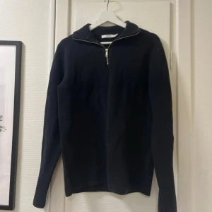 Marinblå/mörkblå  tröja med dragkedja från Premium by Jack & Jones - Säljer en stilren svart tröja från Premium by Jack & Jones. Tröjan har en dragkedja vid halsen och långa ärmar. Perfekt för en avslappnad look.