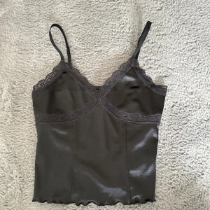 Svart satinlinne med spets - Svart satin linne med spets detaljer från H&M. Oanvänd med lapp kvar.