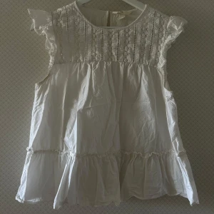 Topp/Blus - En vit söt topp med detaljer från H&M i storlek M.