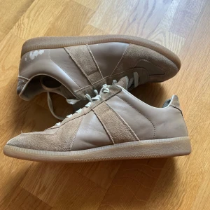 Maison Margiela skor  - Säljer mina Maison Margiela skor i färgen beige. Väldigt snygga och sparsamt använda. Skorna har fått två märken som visar på bilden därav priset. 