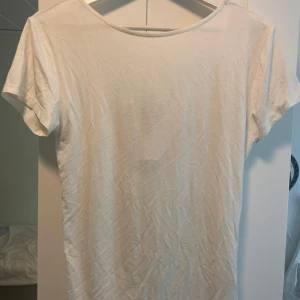 Vit topp med rosett från Lager 157 - Superfin vit topp från Lager 157 med korta ärmar och snygg urringning i ryggen som pryds av en söt rosett. Tunn och mjuk i bomull, perfekt till jeans eller kjol. Enkel men ändå med en twist tack vare knytet bak. Säljer då den är för stor för mig men beroende på hur tight du vill att den sitter passar den nog även S och M också ifall du vill ha den lösare.