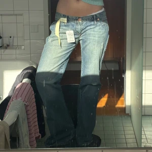 Lågmidjade utsvängda jeans - Så snygga utsvängda jeans med låg midja. De är helt oanvända och har fortfarande alla etiketter kvar. Köpta här på vinted men de är tyvärr lite stora för mig som brukar ha S så skulle rekommendera för någon med storlek M/L beroende på hur man vill att den ska sitta.   Har snygga lite ”slitna” detaljer och är även snyggt randiga i färgen.   Skriv för mått🩷 