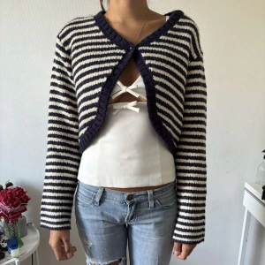 Randig stickad kofta i marinblått och vitt - Superfin stickad kofta med marinblå och vita ränder. Kortare modell med lång ärm och v-ringad öppning framtill. Perfekt att slänga över ett linne eller topp för en chill och trendig look!🌸zara barn 164cm, motsvarar en xs - modellen är 1,70 i bilden!!