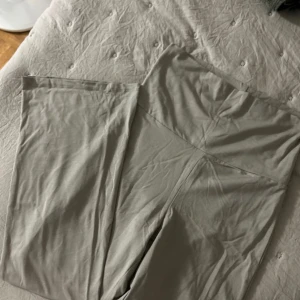 Beige mjukisbyxor från Gina Tricot  - Supersköna mjukisbyxor från Gina Tricot i färgen elephant skin. Byxorna har hög midja med bred linning och raka, vida ben. Tillverkade i mjukt bomullsmaterial som känns riktigt bekvämt mot huden. Perfekta för chill dagar eller när du vill ha det extra comfy.