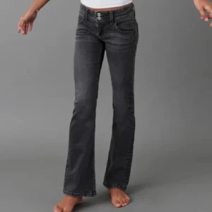 Svarta bootcut jeans med dubbla knappar - Snygga svarta jeans med bootcut-modell och dubbla knappar i midjan.