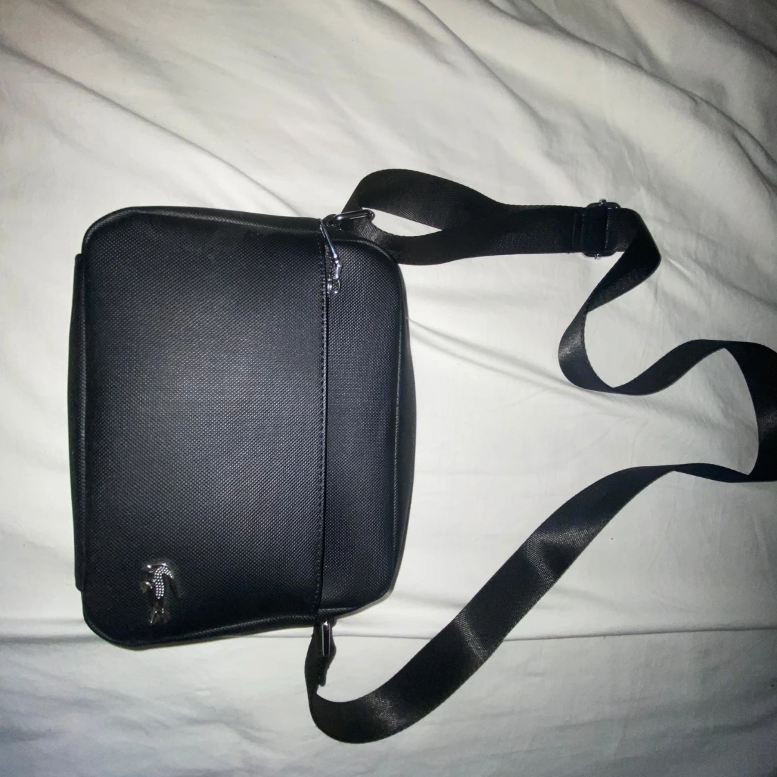 Svart axelväska med justerbart band från Lacoste