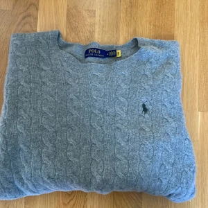Ralph lauren tröja  - Tja jag säljer en Kabelstickad grå tröja från  Ralph Lauren med material av merinoull .OBS Tröjan har storlek M men passar bättre om man har S eller XS. Hör gärna av er vid minsta fundering eller fråga!
