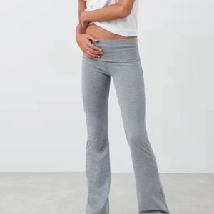 Grå bootcut byxor från Gina Tricot - Har använt cirka 3 gångar ändas för. Byxorna har en mjuk känsla och sitter tajt upptill med utsvängda ben. Perfekta för en chill och trendig look.