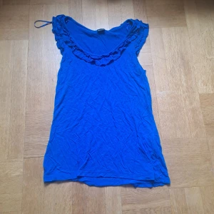 Blå topp med volang  - Supersöt topp från Gina Tricot med volangdetaljer längs urringningen. Färgen är mer åt royal blue. ❤️