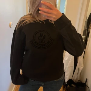 Svart sweatshirt från Moncler - Svart sweatshirt från Moncler med stor logga på bröstet. Tröjan är självklart äkta men då jag fått den har jag ej kvitto, därav priset. 