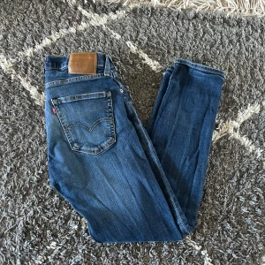 Levi's 512 blå jeans herr - Säljer ett par klassiska Levi's 511 jeans i blå denim. Modellen är slim fit med raka ben och normal midja. Jeansen har fem fickor, Levi's ikoniska röda etikett och snygga slitningar för en cool look. Storlek 30/30