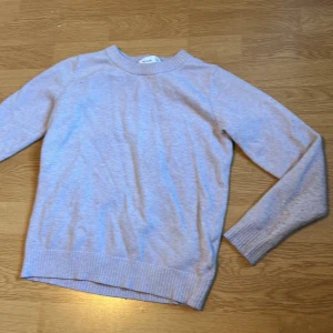 Lila stickad tröja från Vila - Mysig lila stickad tröja från Vila i storlek XS. Tröjan har rund halsringning, ribbade muddar och lång ärm. Perfekt för lager-på-lager och chill dagar. Enkel och stilren design som funkar till det mesta.