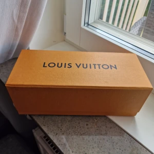 Louis Vuitton tom parfymlåda - Kan fixas fri frakt men kontakta mig innan köp. Säljer en exklusiv Louis Vuitton tom låda från parfym i klassisk orange färg med svart logotyp. Kartongen har en lyxig känsla och är stadig med en insida i beige ton. Den här lådan följde med när parfymen köptes. Den inre delen där parfymen låg kan tas bort, vilket ger mer utrymme i asken. Original.