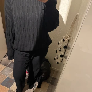 Svart stickad tröja från BikBok - Säljer en svart stickad tröja från BikBok i storlek M. Tröjan har ett snyggt kabelstickat mönster och långa ärmar med ribbade muddar. Perfekt för lager-på-lager särskilt till kommande kyliga sommarkvällar. 