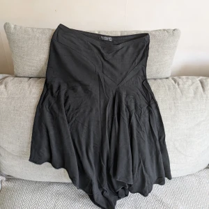Svart kjol från Sisters Point - Svart kjol från Sisters Point med snygg asymmetrisk nederkant. Kjolen är i skönt och luftigt material och har en följsam passform. Jag är ca 170 cm för referens. Vid köp av flera klädesplagg av mig samfraktar jag såklart!