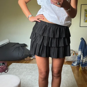 Svart plisserad volangkjol - Supersnygg svart kortkjol med volanger  