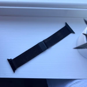 Svart klockarmband i metall till Apple Watch (38/40/41mm) - Snyggt svart metallarmband till Apple Watch med magnetlås. Tillverkat i metall med en stilren och modern känsla. Perfekt för dig som vill ge din klocka en clean och minimalistisk look. Passar direkt på Apple Watch och är lätt att byta. Är lite avskavt - framkommer på bilderna. 🖤 Önskar du veta exakta mått? Tveka inte att höra av dig!