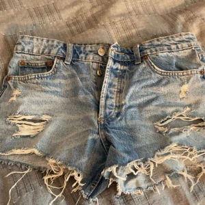 Lågmidjade jeansshorts  - Super snygga jeansshorts med slitningar från Zara. De har en lågmidja och knappgylf, perfekta för sommaren. Jag säljer de då de är för stora. Kom privat för frågor o bilder💓💓 !priser diskuteras vid snabb affär!