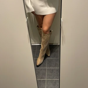Beiga mocka cowboy boots med klack - Snygga höga cowboy boots i beige mocka med spetsig tå från H&M.🤎Blev helt kär i dessa men dem har tyvärr inte kommit till användning, endast testade och så bekväma att gå i då dem inte är superhöga. Slutsålda på hemsidan