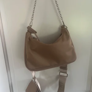 Beige axelväska  - Säljer en beige p*ad* väska ej använd. Köpt på second hand sida men fick inte med kvitton som sagt så kan inte säga att den är äkta därav priset. 