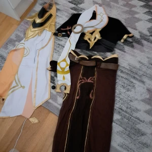 Aether cosplay - Säljer min aether/traveller genshin cosplay, endast prövad av mig en gång, har ej använt mer än det så säljer den då den ej kommit till användning^^ allt som syns på bilden är inkluderat, saknas en del accessoarer som jag själv inte fick med då jag köpte den tyvärr:( står att det är storlek L men tycker den passar mer som en S-M!