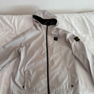 Ljusgrå vindjacka från Stone Island - Snygg ljusgrå vindjacka från Stone Island  Är du intresserad av plagget är de bara att skriva.  Vill du ha billigare genom bundle eller lika feta kläder kolla bara in min profil och gör ett bundle och skriv till mig. Storlek L/m (Vattentät)