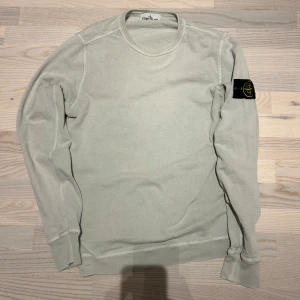 Stone Island  - Säljes: En original Stone Island sweatshirt i klassisk créme färgad/vit. Denna tröja är det perfekta valet för dig som vill ha en stilren och tidlös look med en touch av lyx. 100% äkta Detaljer: • Märke: Stone Island • Färg: créme färgad/vit • Storlek:M • Skick: 10/10 • Material: Bekvamt och slitstarkt tyg Trojans ikoniska Stone Island-kompasslogotyp på vänster ärm gör den igenkännbar och ger en exklusiv touch. Den är perfekt för bäde vardagsbruk och vardagliga tillfällen.