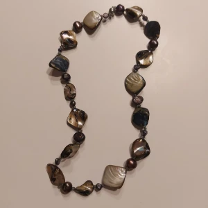 Halsband med oregelbundna pärlor - Unikt halsband med oregelbundna pärlor i olika nyanser. Pärlorna har en skimrande yta som ger ett elegant intryck. Perfekt för att ge en personlig touch till din stil. Med ett metall lås. Skriv om ni har någon fundering!✨️