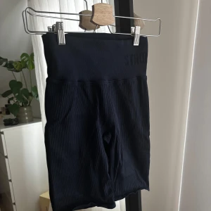 Marinblå ribbade träningsshorts  - Snygga marinblåa ribbade shorts med hög midja. Perfekta för träning eller en avslappnad dag. De har en tight passform som ger en smickrande siluett. Enkla att matcha med olika toppar för en stilren look.