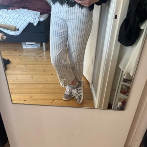 Randiga vita byxor - Snygga vita jeans med svarta ränder från Monki. De har en fläck som visas på sista bilden men är annars i fint skick!