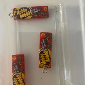 3st Hubba Bubba Berlocker - Unika berlocker formade som Hubba Bubba-tuggummipaket i rött med gula och blå detaljer. Perfekta för den som vill ha en rolig och färgglad accessoar. 3 ST ingår 💓
