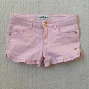 Rosa shorts från Hampton Republic - Säljer ett par söta rosa shorts från Hampton Republic. De har en klassisk femficksdesign med knapp och dragkedja framtill. Perfekta för varma sommardagar! 🌸