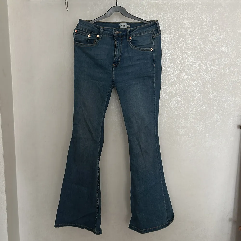 Säljer ett par snygga blå bootcut jeans från 157. De har en klassisk femficksdesign och är perfekta för en avslappnad stil. Jeansen är i storlek M/32 och har en kortare längd, vilket gör dem idealiska för dig som vill ha en bekväm passform. Jag har använt dom väldigt lite, jag är cirka 160 cm lång. Nypriset är 200kr. Farkut & Housut.
