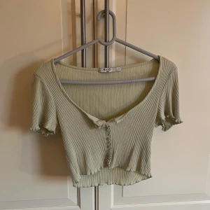 Grön ribbad topp från NA-KD - Snygg grön ribbad topp från NA-KD med korta ärmar och knappar framtill