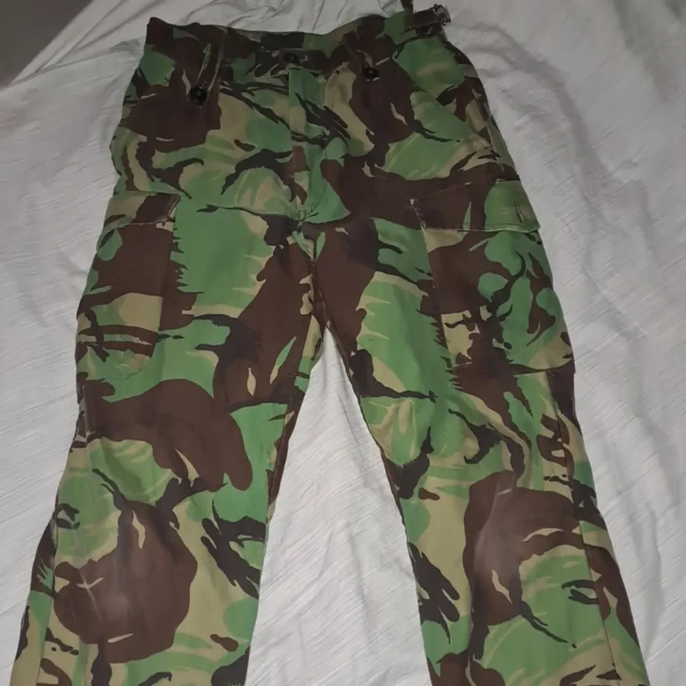 Säljer ett par coola camouflage cargopants med flera praktiska fickor och justerbar midja. Perfekta för en avslappnad och äventyrlig stil. Passar bra för utomhusaktiviteter och har en loose passform.. Farkut & Housut.
