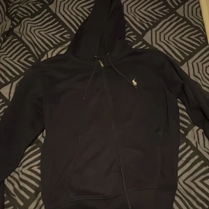 Mörk blå Ralph Lauren zip - Säljer min mörk blå Ralph lauren zip! Är ett par månader gamla. Lite sönder på snöret runt om luvan på bilden. Men inga mer skador!!!