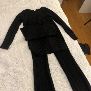 Svart ribbad tröja från Shein - Säljer en svart ribbad tröja från Shein i storlek 12-13 år. Tröjan har långa ärmar och en stilren design som passar perfekt för olika tillfällen. Perfekt för den som vill ha en bekväm och snygg outfit.