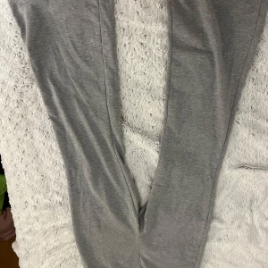 Grå mjukisbyxor - Säljer ett par grå mjukisbyxor i mjukt material. Perfekta för en avslappnad dag hemma eller på språng. De har en bekväm passform och är lätta att matcha med olika toppar.