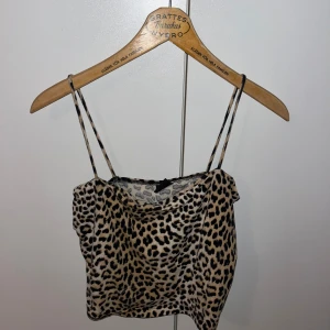 Festtopp  - Säljer en snygg leopardmönstrad linnetopp från Gina Tricot. Toppen har smala axelband och är perfekt för en trendig look. Passar bra till både jeans och kjol. Passar mig som brukar ha s skriv för fler bilder 