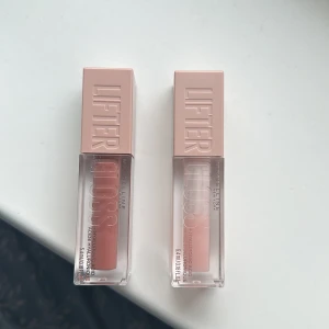 Maybelline Lifter Gloss - Maybelline Lifter Gloss med hyaluronsyra för fylligare läppar. Finns i två nyanser: en djup rosa och en ljus nude. Den har en mjuk applikator för enkel applicering och ger en glansig finish. Färgerna heter ”004 SILK” och ”002 ICE” 004 SILK är det ungefär 75% kvar och 002 ICE är det ungefär 40% kvar. Dom kommer säljas tillsammans och inte var för sig. Nypris är 139kr styck.
