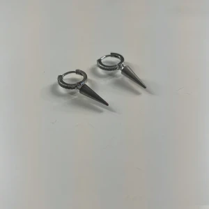 Svarta örhängen med spetsdetalj - Snygga svarta örhängen med en unik spetsdetalj. Perfekta för att ge en edgy touch till din stil. De är små och lätta, vilket gör dem bekväma att bära hela dagen.